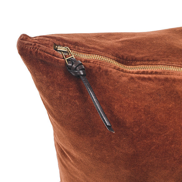 Funda de cojín de terciopelo color terracota con tirador de triple nudo de cuero
