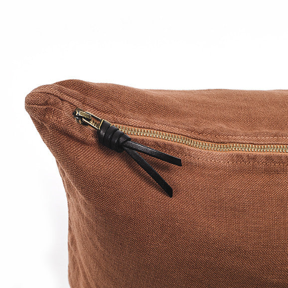 Funda de cojín de lino color terracota con tirador de triple nudo de cuero