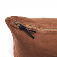 Funda de cojín de lino color terracota con tirador de triple nudo de cuero