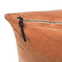 Funda de cojin de terciopelo color salmon con tirador de triple nudo de cuero